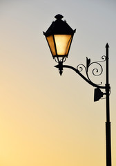 Fototapeta na wymiar Street antique style lamp post with effect of shine from low light of sunset (vertical take)