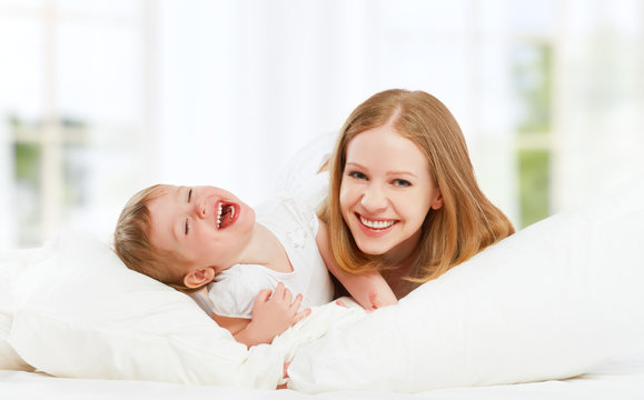 happy family mother and baby daughter playing and laughing baby