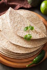 whole wheat tortillas on wooden board and vegetables