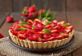 Tart with strawberries and whipped cream decorated with mint leaves