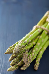 bunch of fresh asparagus on blue background