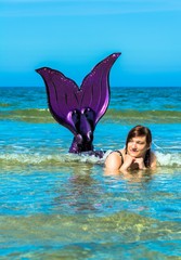 Meerjungfrau hebt die Flosse aus dem Wasser © Andrea