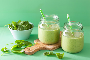 healthy green smoothie with spinach mango banana in glass jars