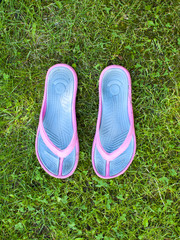Summer Slippers are on the grass.