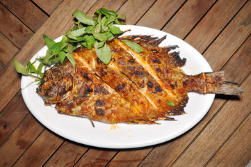 Grilled rabbitfish on a dish on the table in restaurant