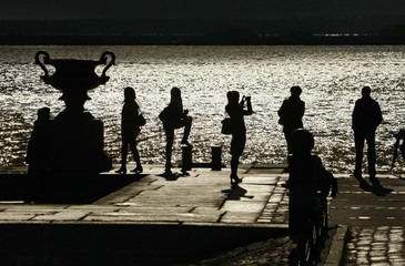 silhouettes of people on the waterfront