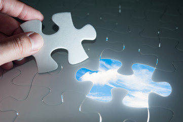 Jigsaw piece with sky in hole, conceptual image