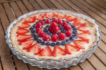 Tart decorated with strawberries blueberries and raspberries