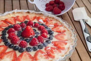 Tart decorated with strawberries blueberries and raspberries