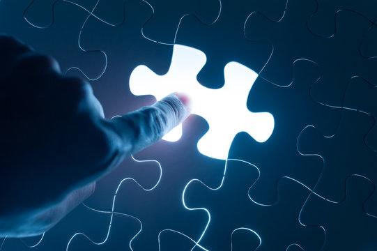 Hand press on jigsaw, conceptual image of business strategy