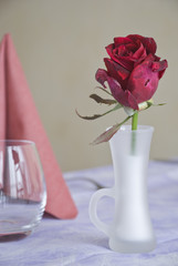 il vasetto di vetro opaco con la rosa rossa ,fanno da centrotavola