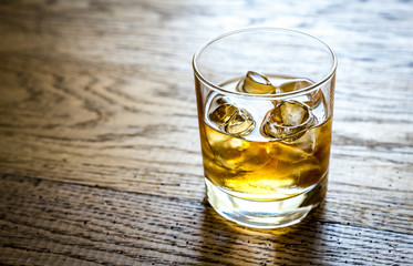 Glass of rum on the wooden background