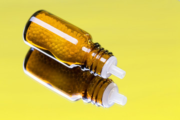 bottle with homeopathy globules laying on a mirror