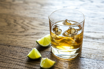 Glass of rum on the wooden background