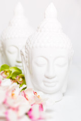 Two decorative statues of Buddha with orchids