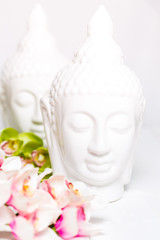 Two decorative statues of Buddha with orchids