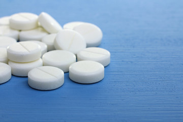 Fototapeta na wymiar White pills on a blue background
