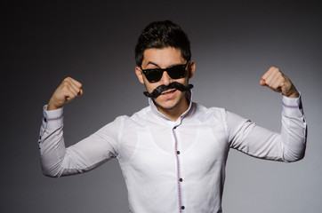 Young man in black sunglasses isolated on gray