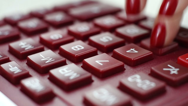 The hand presses the button on the calculator