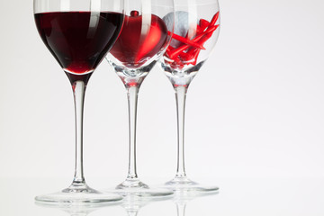 Wine glasses with red wine, heart and golf ball