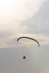 Paraglider with a motor on a background of gray sunset sky
