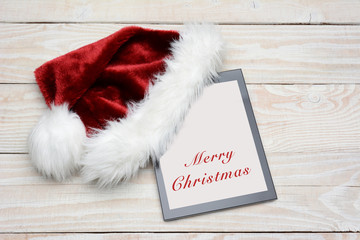 Obraz na płótnie Canvas Santa Hat With Happy Holidays Tablet