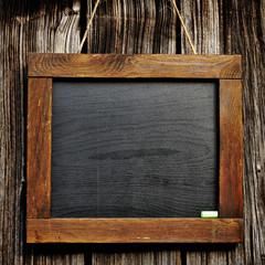 Vintage slate chalk board hanging on wooden background