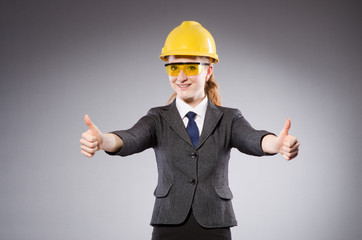 Female engineer with helmet isolated on gray