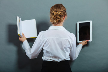 Woman holding traditional book and e-book reader