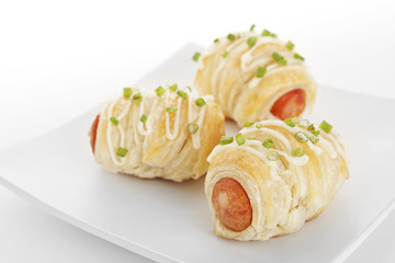 Tree delicious Sausage rolls puff on plate topping with mayonnai