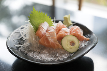 Fresh Salmon belly sashimi in plate on black table