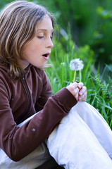 girl blowing a dandelion
