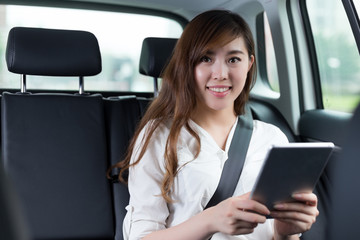 Fototapeta na wymiar Beautiful asian woman using digital tablet in car