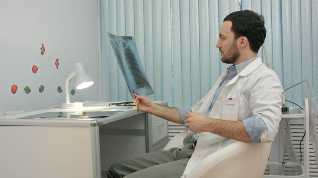 Male doctor or dentist looking at x-ray
