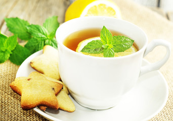 Cup of tea with slice of lemon and home made cookies. Selective focus
