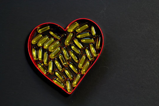 Fish Oil Omega-3 Capsules In Heart Shape With Black Background