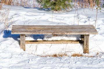 Wooden bench on a winter trail