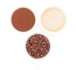 drei Tassen mit Kaffee, Kaffeebohnen und Kaffeepulver