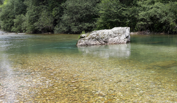 Rock in the clear stream with cold water
