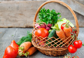 Sets with organic vegetables on a wooden background.