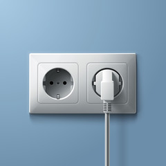 Electric white plug and socket on blue wall background