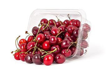 Obraz na płótnie Canvas Box or punnet and spilled fresh ripe organic cherries isolated on white background