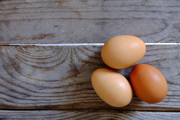 Three eggs lay on a wooden table