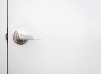 Detail of a metallic knob on white door