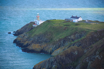 Fototapeta na wymiar Lighthouse on a cliff in the sea with a helipad.