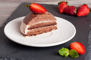 Chocolate cake with strawberry on wooden table