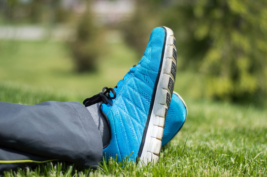 Blue shoed young man laying on grass