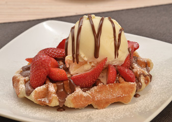 Waffle con helado de vainilla,fresa y crema de chocolate.