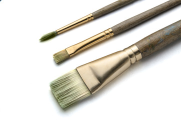 Fototapeta premium Three art paint brushes on white