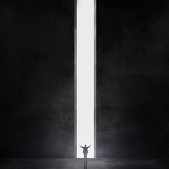 Silhouette of businessman standing in a gap of air in a dark room